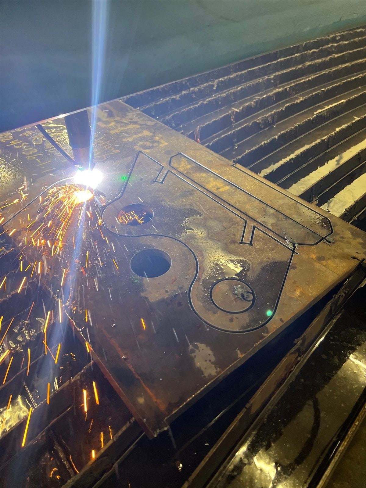 CNC plasma table cutting steel with sparks flying at Emerald City Industrial